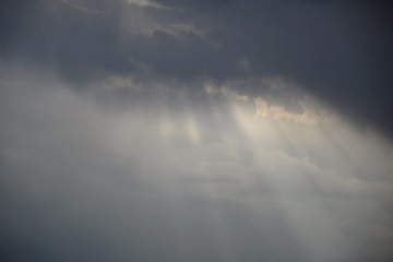 Naklejka na ściany i meble Rays of sunlight passing through the clouds
