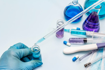Fototapeta premium Female hand holds a test tube. Laboratory studies of coronavirus. Worldwide pandemic COVID-19, 2019-nCoV, SARS-CoV-2