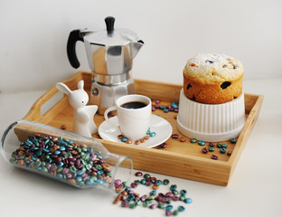 Easter still life. Coffee and cake. Espresso maker moka pot. White dishes, ceramic easter bunny. Colored coffee beans