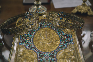 Wedding ceremony closeups in an orthodox church with crowns and wedding rings. 