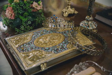 Wedding ceremony closeups in an orthodox church with crowns and wedding rings. 