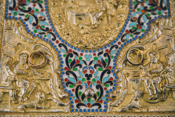 Wedding ceremony closeups in an orthodox church with crowns and wedding rings. 