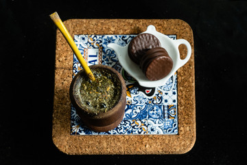 Mate, alfajores sobre un posadero de corcho