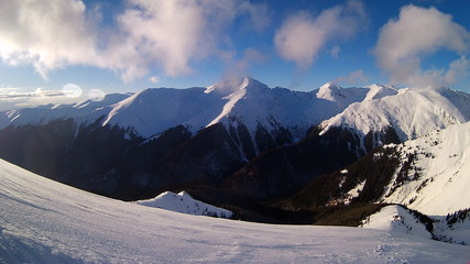 winter landscape mountains with frozen forest and snow on trees in sunny day