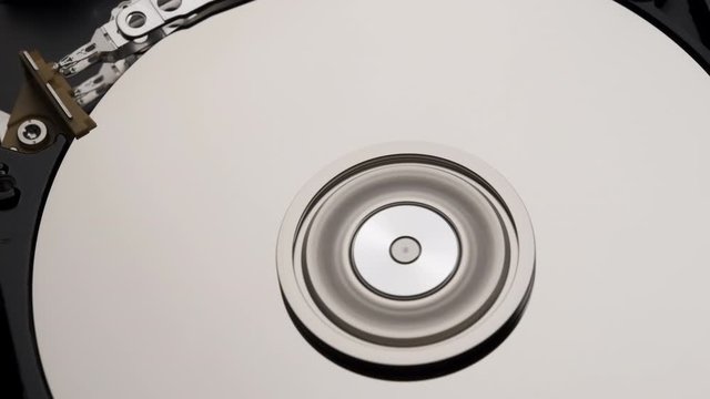 Macro, Close-Up of Computer Hard Disk Drive Spinning and Writing then Rotation Stop. 4k
