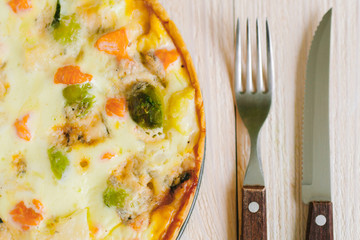 smoked salmon, Brussels sprouts and gorgonzola quiche tart with fork and knife, top view close up