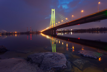 The South bridge at night, Kyiv, Ukraine. Bridge at sunset across the Dnieper River. Kyiv bridge against the backdrop of a beautiful sunset in Kyiv. 