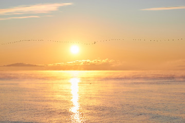Dawn over the sea with clouds and fog