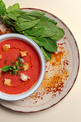 Homemade tomato soup with bread, mint and olive oil