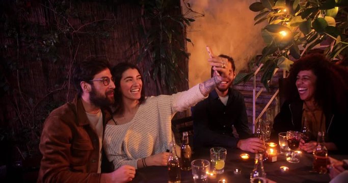 Caucasian couple taking selfie with smartphone during friends patio party