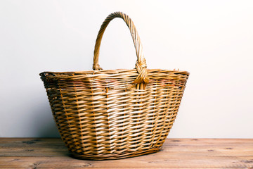 Fototapeta na wymiar Large wicker basket on a wooden table 