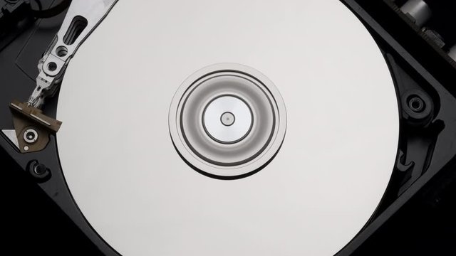 Macro, Close-Up of Computer Hard Disk Drive Spinning and Writing then Rotation Stop. Blue Lights Blinking. 4k 