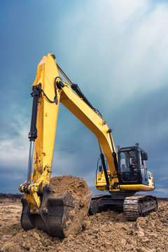 A large construction excavator of yellow color on the construction site in a quarry for quarrying. Industrial image