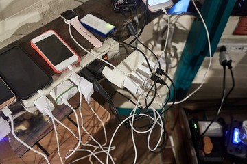 Lots of chargers for devices tangled in a crowded corner