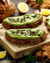 Healthy Homemade Avocado creamy Toast with nuts mix on wooden board