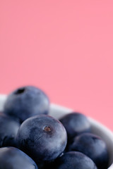Close up blueberries on pink background. Fresh fruits macro.