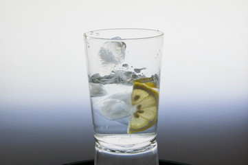 Lemon slice splash effect when falling into a glass with water