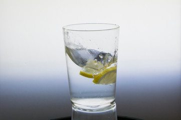 Lemon slice splash effect when falling into a glass with water