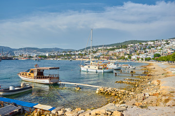 Fototapeta na wymiar View of Bodrum Beach, Aegean sea, traditional white houses, flowers, marina, sailing boats