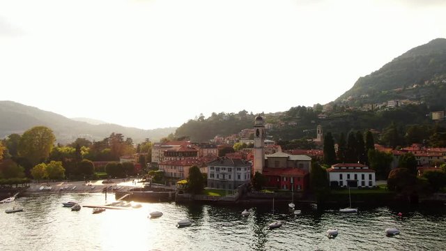 Cernobbio is a popular holiday resort in Italy on Lake Como. Beautiful aerial view of the sunset on a summer day. Beautiful Italian houses on the slopes of green mountains. Drone shooting