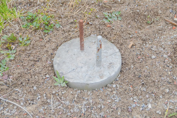 concrete post with rebar for building a house is driven into the ground