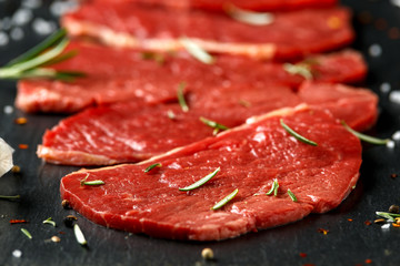 Raw fresh sizzling beef steak with herbs on stone board