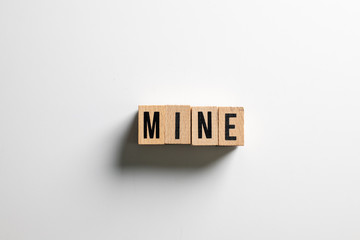 " mine " text made of wooden cube on  White background.