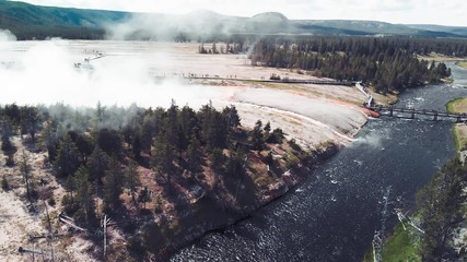 Midway Geyser Basin a smaller basin alongside the Firehole River. The largest hot spring in Yellowstone, Grand Prismatic Spring is also found here