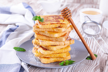 Fresh homemade crispy toast with honey on white wooden table