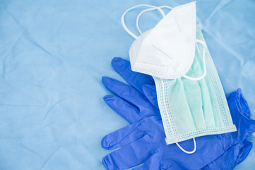 Different face mask and blue latex gloves on blue background.Medical tool for personal protection equipment.Medical accesory for infectious control concept.