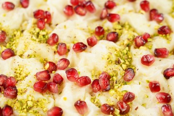 Traditional Turkish Ramadan Dessert Gullac . It is made with gullac (rice wafer or rice sheets) , milk, rose water, walnut, vanilla.  It is decorated with pomegranate and pistachio.