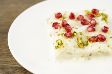 Traditional Turkish Ramadan Dessert Gullac . It is made with gullac (rice wafer or rice sheets) , milk, rose water, walnut, vanilla.  It is decorated with pomegranate and pistachio.