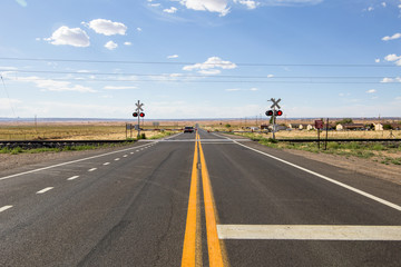 A track railway  crossing on the two-lane rural Mojave desert highway - old Route 66. Dry arid...