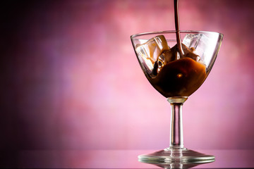 glass of coffee liqueur with ice cubes