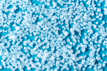 white crystals of coarse salt on blue background