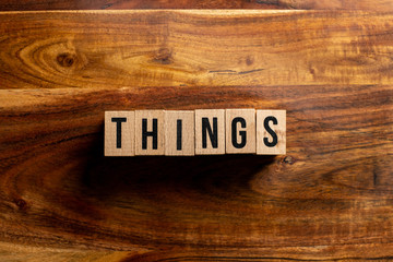 " things " text made of wooden cube on  wooden background.