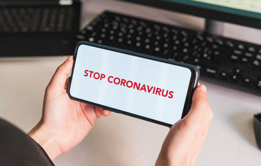 Stop coronavirus. Put your message on the phone. Hands of a woman holding a mobile phone with a blank screen to put a text message or advertising content. Social distance. Coronavirus devices. 