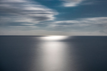 Fototapeta na wymiar Paisaje del horizonte del mar con la luz de la luna reflejada en el agua.
