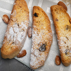 Traditional italian biscuits, biscotti, cantuccini with nuts and raisins, sprinkled with powdered sugar