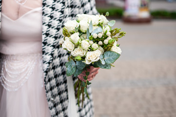 White bouquet of roses in the hnad of bride