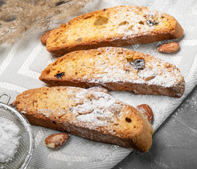 Traditional italian biscuits, biscotti, cantuccini with nuts and raisins, sprinkled with powdered sugar
