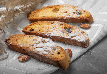 Traditional italian biscuits, biscotti, cantuccini with nuts and raisins, sprinkled with powdered sugar