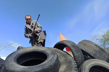 armed fighter with firearms on barricades of car tires