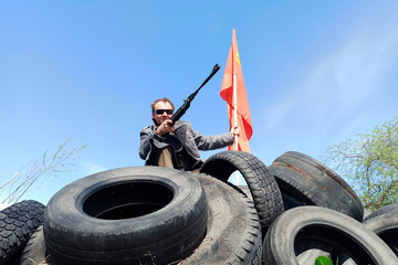 armed fighter with firearms on barricades of car tires