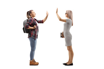 Obraz premium Female student gesturing high-five with a woman holding books