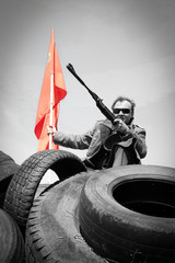 armed fighter with firearms on barricades of car tires