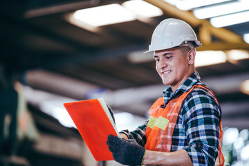 Portrait handsome smart engineer male manager working on construction repair checklist document in modern industrial manufacturing factory. worker man in protective uniform work hard. copy space