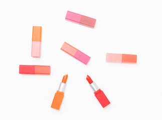 top view of colorful pastel lipstick arranged on white background