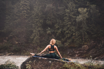 Naklejka premium The woman in the wood, meditation outdoors yoga mountain green