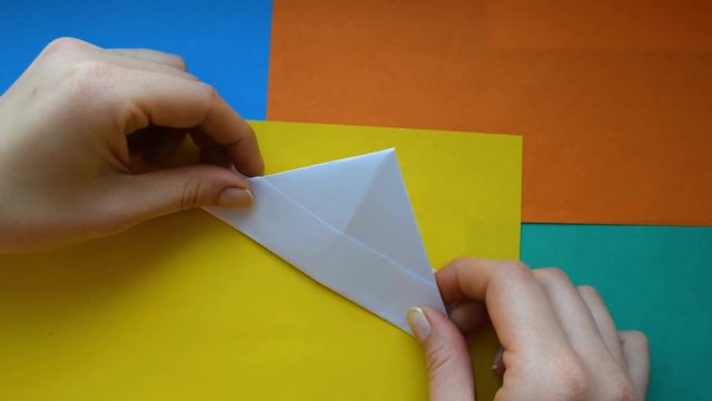 Step 5. female hands make paper boat. Step-by-step instructions on how to make origami paper ship.